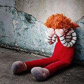poupée de chiffon adossée à un mur
